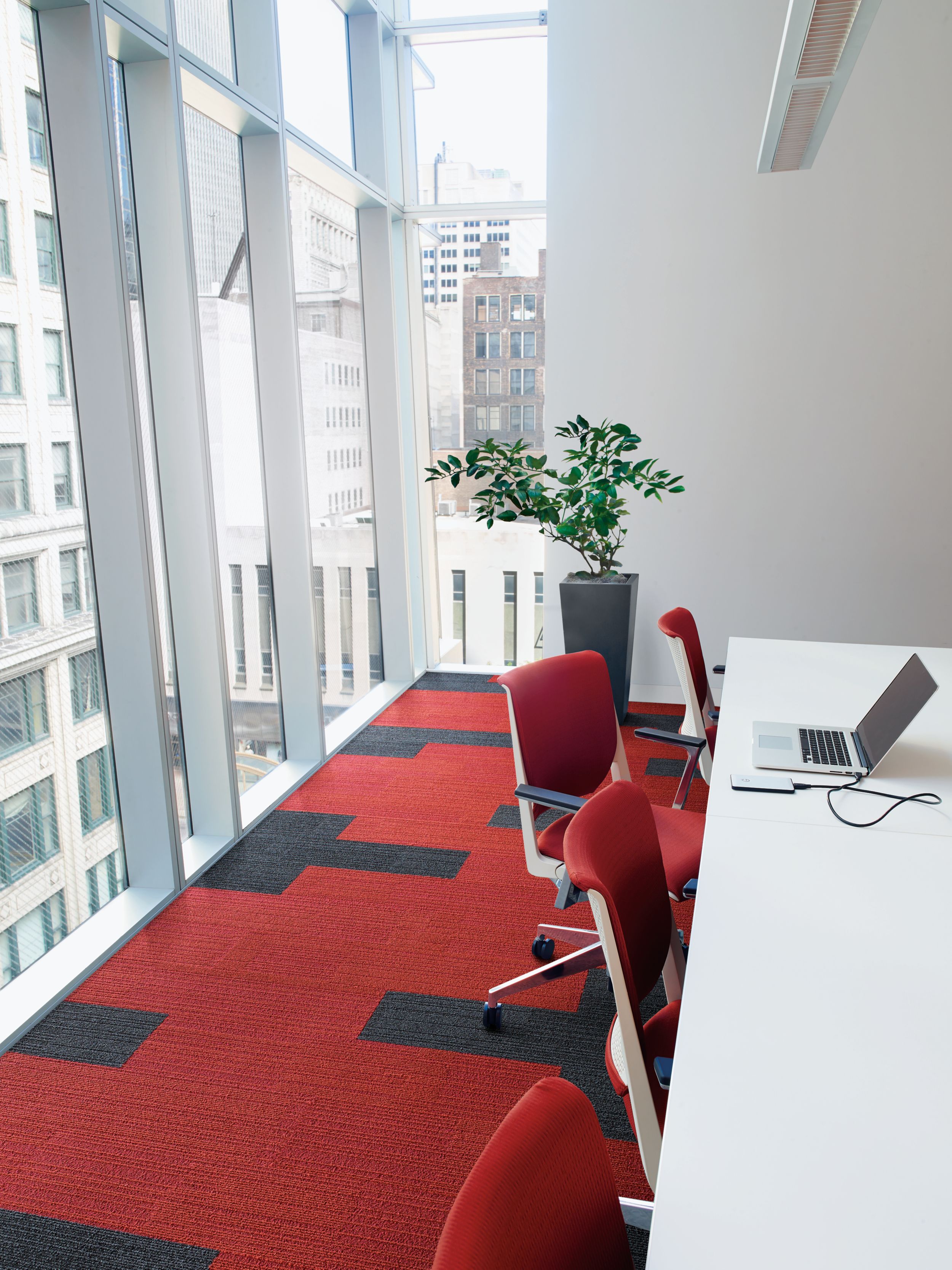 Interface On Line plank carpet tile in corner working space with angled windows overlooking highrise office buildings imagen número 3